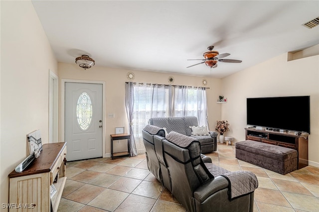 living area featuring a ceiling fan, visible vents, light tile patterned floors, and a healthy amount of sunlight