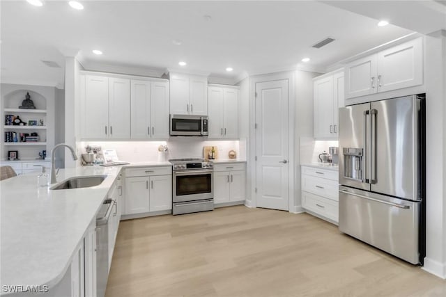 kitchen with stainless steel appliances, visible vents, a sink, and white cabinetry