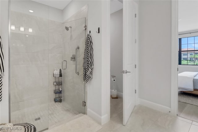 ensuite bathroom with baseboards, tile patterned flooring, ensuite bathroom, and a stall shower