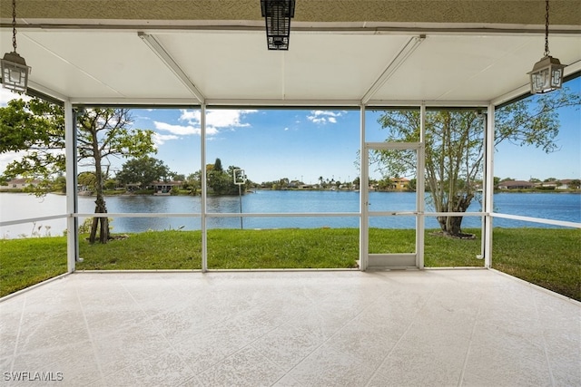 unfurnished sunroom featuring expansive windows, a wealth of natural light, and a water view
