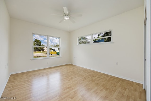 spare room with light wood finished floors, baseboards, and ceiling fan