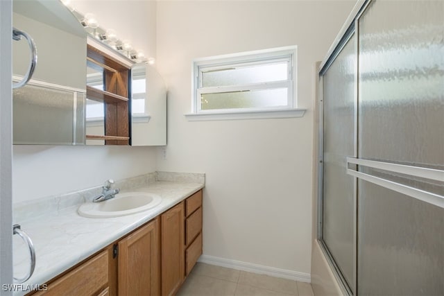 full bath with baseboards, vanity, and tile patterned flooring