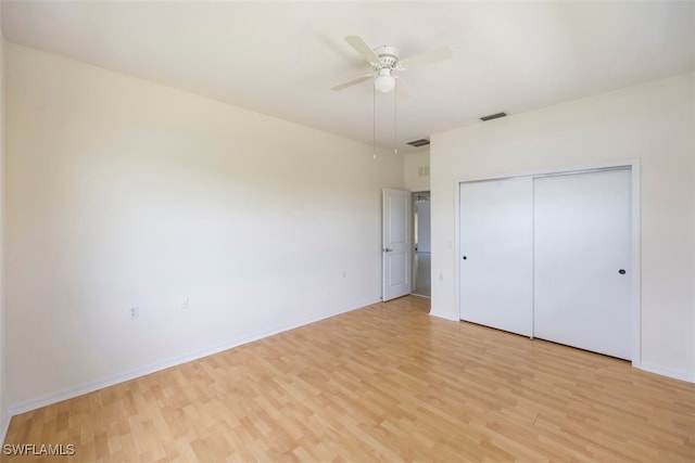 unfurnished bedroom with baseboards, visible vents, light wood finished floors, and a closet