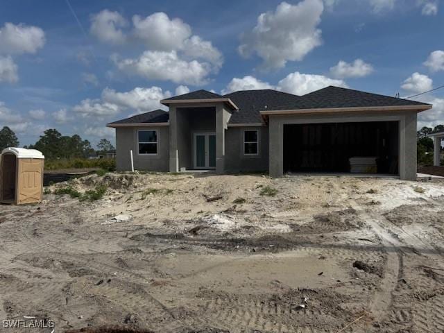 2918 29th St W, Lehigh Acres, FL 33971 - view of front of property featuring an attached garage, stucco siding, and french doors