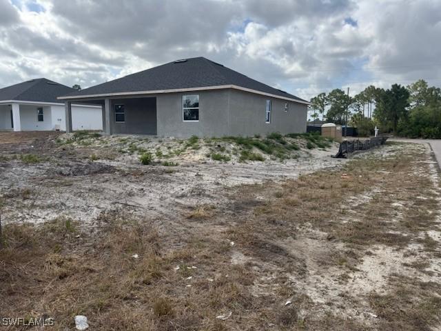 2918 29th St W, Lehigh Acres, FL 33971 - view of side of property featuring stucco siding