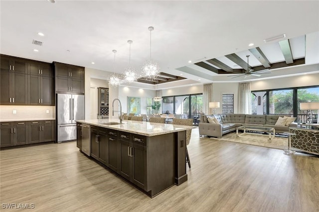 kitchen featuring appliances with stainless steel finishes, open floor plan, visible vents, and a sink