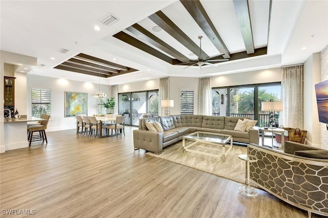 living area featuring visible vents, ceiling fan, wood finished floors, and baseboards
