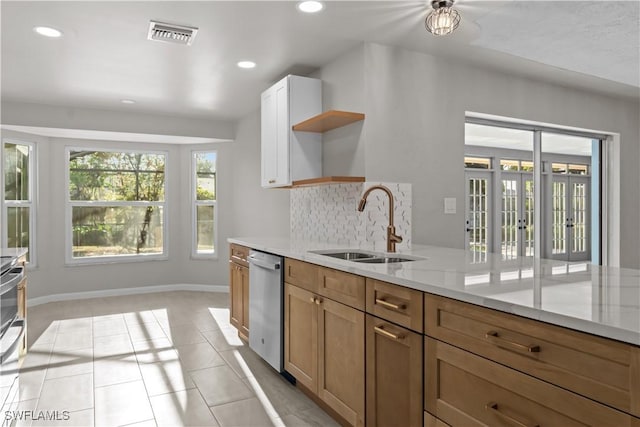 kitchen featuring stainless steel dishwasher, a sink, open shelves, and recessed lighting