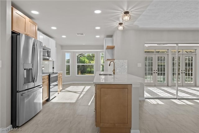 kitchen featuring open shelves, appliances with stainless steel finishes, a sink, french doors, and visible vents