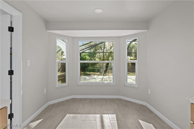 unfurnished room with baseboards