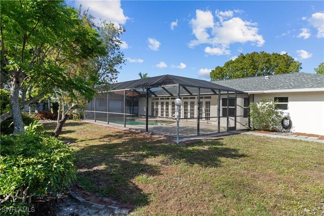 back of house with a yard, a lanai, an outdoor pool, and stucco siding