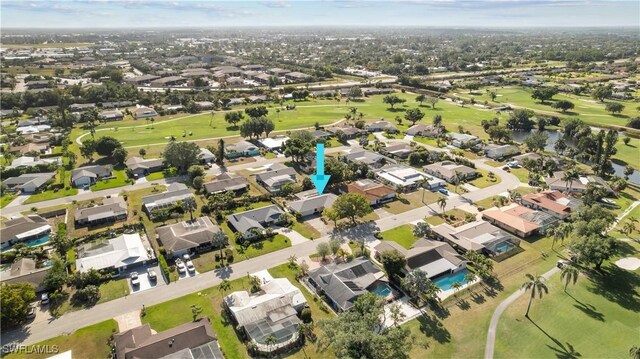 bird's eye view featuring a water view, view of golf course, and a residential view
