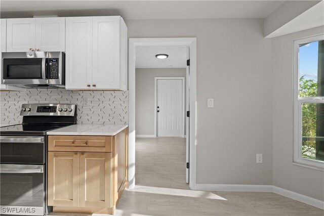 kitchen with baseboards, plenty of natural light, tasteful backsplash, and stainless steel appliances