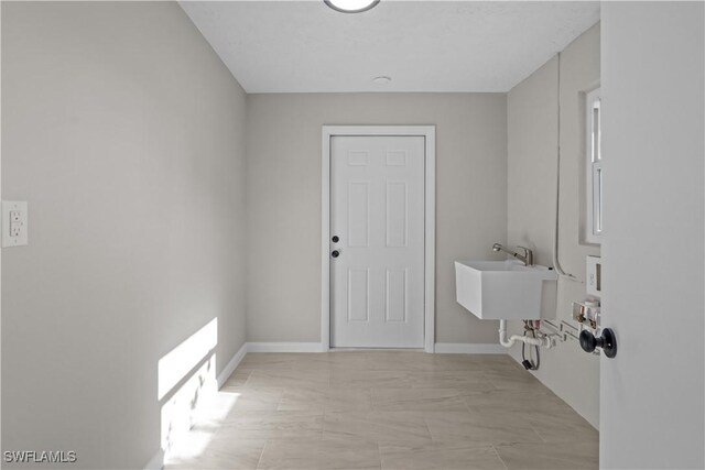 washroom with baseboards, a sink, and marble finish floor