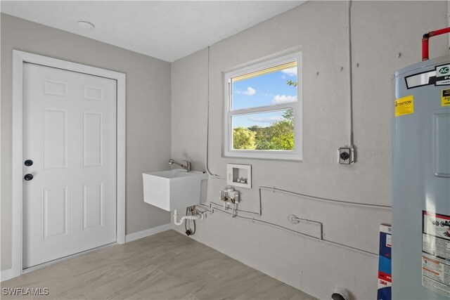 clothes washing area with washer hookup, laundry area, electric dryer hookup, a sink, and electric water heater