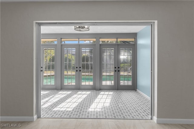 doorway to outside featuring french doors, baseboards, and a wealth of natural light