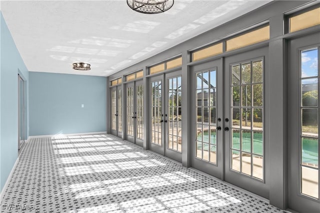 doorway featuring baseboards, french doors, and carpet flooring