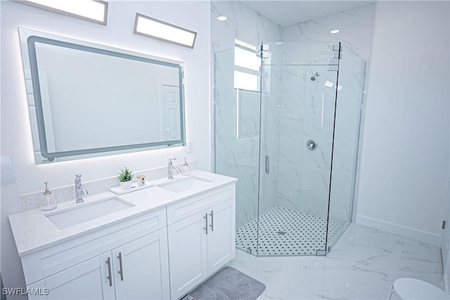 bathroom featuring marble finish flooring, a marble finish shower, double vanity, and baseboards