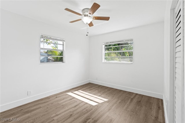3433 Hibiscus Ave, Naples, FL 34104 - unfurnished room with ceiling fan, a healthy amount of sunlight, wood finished floors, and baseboards