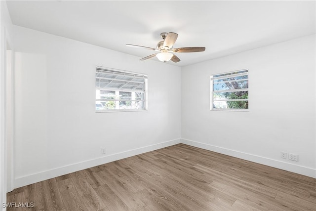3433 Hibiscus Ave, Naples, FL 34104 - unfurnished room with plenty of natural light, baseboards, a ceiling fan, and wood finished floors