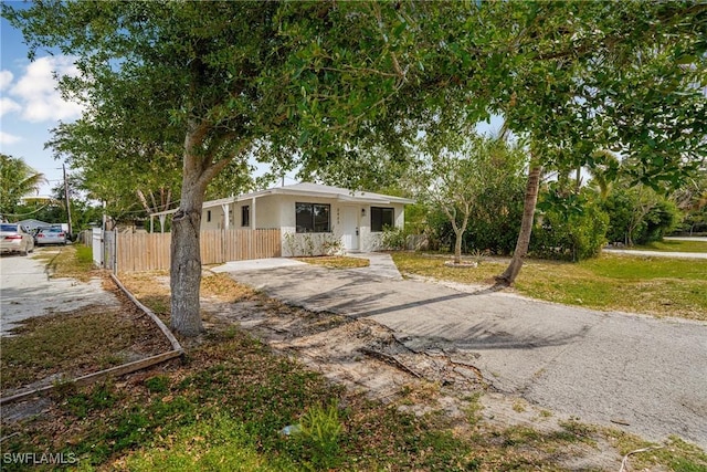 3433 Hibiscus Ave, Naples, FL 34104 - view of front facade with aphalt driveway, fence, and stucco siding