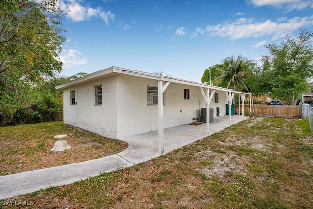 3433 Hibiscus Ave, Naples, FL 34104 - view of home's exterior with a lawn, a fenced backyard, a patio, central air condition unit, and stucco siding