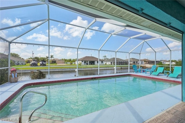 pool featuring a lanai, a patio area, a residential view, and a water view