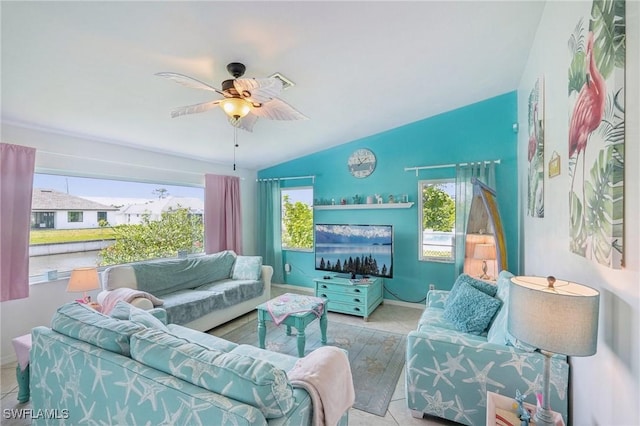 living area featuring tile patterned floors, lofted ceiling, baseboards, and ceiling fan
