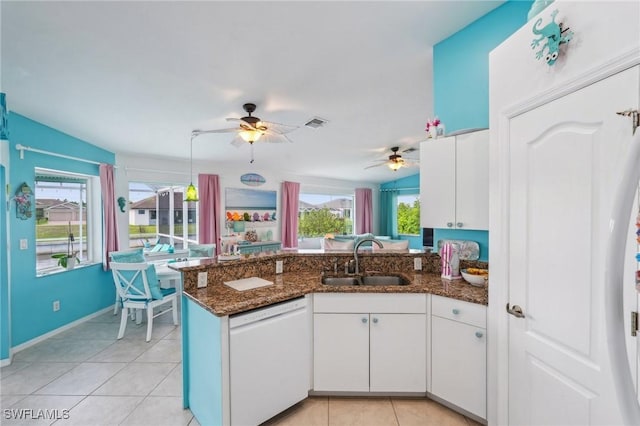 kitchen featuring a peninsula, a ceiling fan, light tile patterned flooring, dishwasher, and a sink