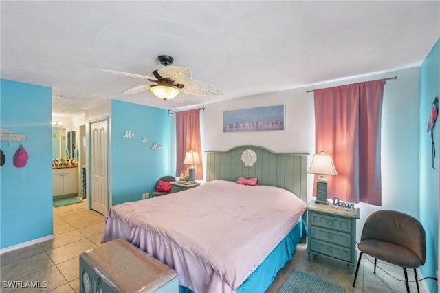bedroom with ensuite bathroom, tile patterned floors, ceiling fan, and baseboards