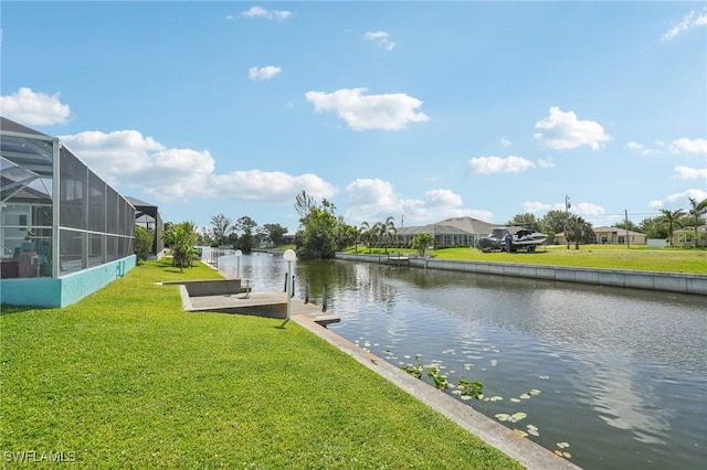 dock area with a water view, a yard, and a lanai
