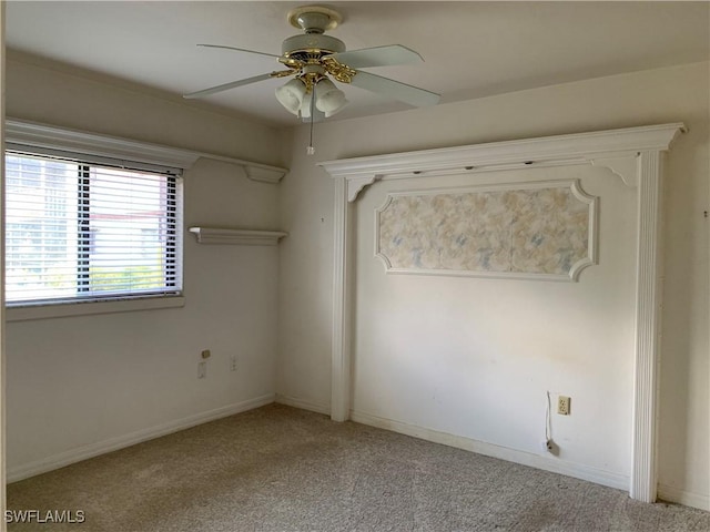 spare room with ceiling fan, light carpet, and baseboards