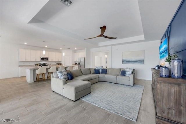11477 Canopy Loop, Fort Myers, FL 33913 - living area with a tray ceiling, ceiling fan, recessed lighting, and light wood-type flooring