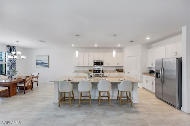 11477 Canopy Loop, Fort Myers, FL 33913 - kitchen featuring appliances with stainless steel finishes, recessed lighting, white cabinetry, a chandelier, and light stone counters