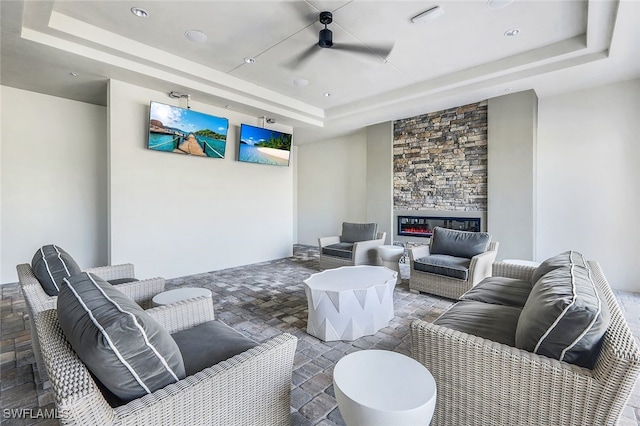 11477 Canopy Loop, Fort Myers, FL 33913 - living area with a tray ceiling, stone tile floors, and a fireplace