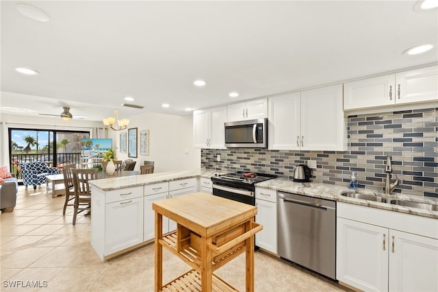 671 E Gulf Dr Unit 2C2, Sanibel, FL 33957 - kitchen featuring a peninsula, white cabinets, appliances with stainless steel finishes, a sink, and decorative backsplash