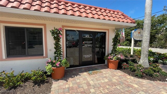 671 E Gulf Dr Unit 2C2, Sanibel, FL 33957 - property entrance with stucco siding and a tile roof