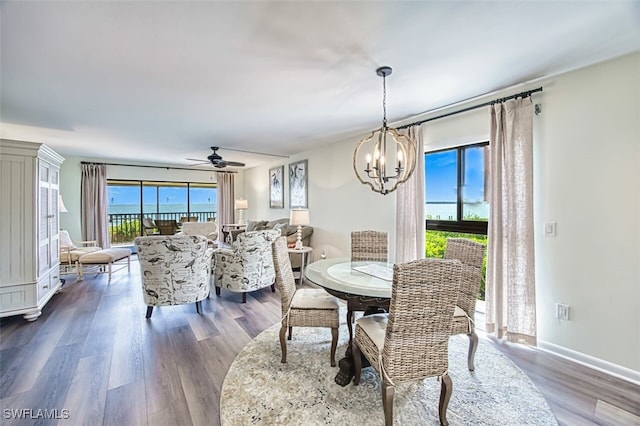 15123 Captiva Dr Unit 104, Captiva, FL 33924 - dining area featuring ceiling fan with notable chandelier, baseboards, and dark wood finished floors