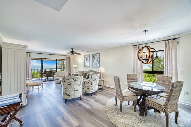 15123 Captiva Dr Unit 104, Captiva, FL 33924 - dining space featuring baseboards, ceiling fan with notable chandelier, and wood finished floors