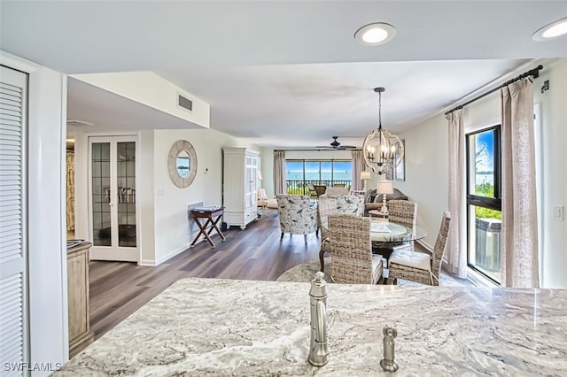 15123 Captiva Dr Unit 104, Captiva, FL 33924 - dining area with visible vents, baseboards, wood finished floors, and ceiling fan with notable chandelier