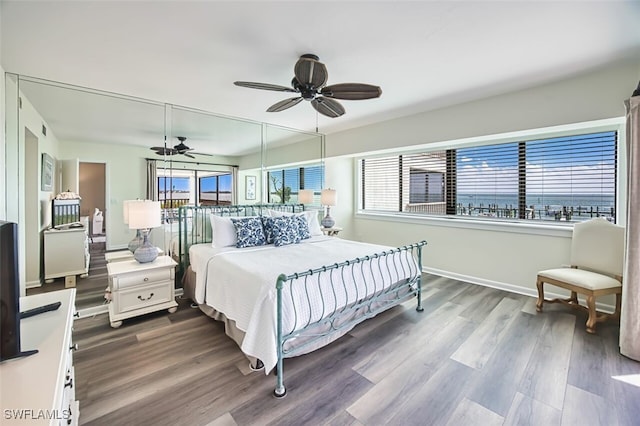 15123 Captiva Dr Unit 104, Captiva, FL 33924 - bedroom featuring ceiling fan, dark wood-style flooring, baseboards, and multiple windows