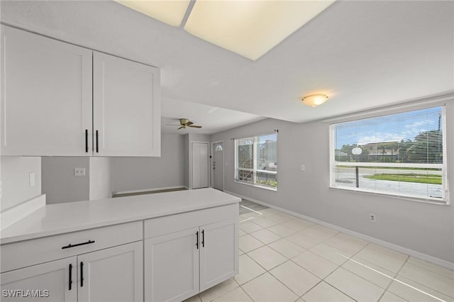 5032 Chiquita Blvd S Unit 101, Cape Coral, FL 33914 - kitchen featuring white cabinetry, light tile patterned flooring, light countertops, a peninsula, and baseboards