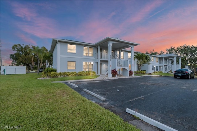 5032 Chiquita Blvd S Unit 101, Cape Coral, FL 33914 - view of front of property with uncovered parking, a lawn, stucco siding, and stairway