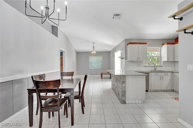 kitchen featuring visible vents, a sink, backsplash, and light tile patterned flooring