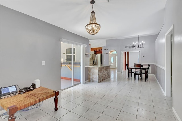 interior space featuring light tile patterned floors, baseboards, and a notable chandelier