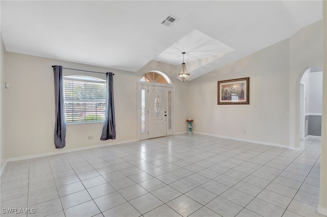 foyer featuring baseboards, vaulted ceiling, light tile patterned floors, visible vents, and arched walkways