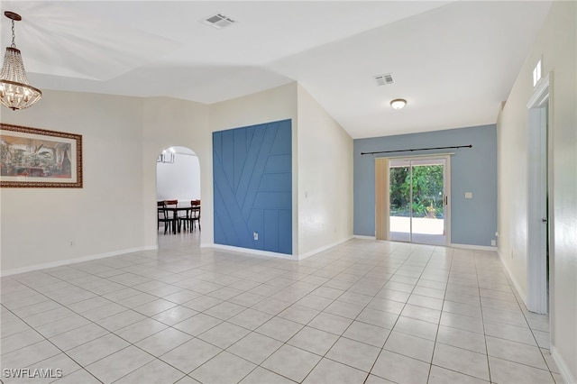 empty room featuring visible vents, arched walkways, an inviting chandelier, and lofted ceiling