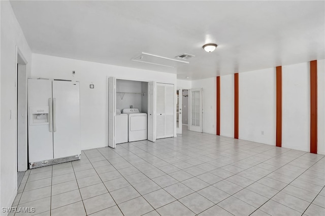 unfurnished room featuring washer and dryer, attic access, light tile patterned flooring, and visible vents
