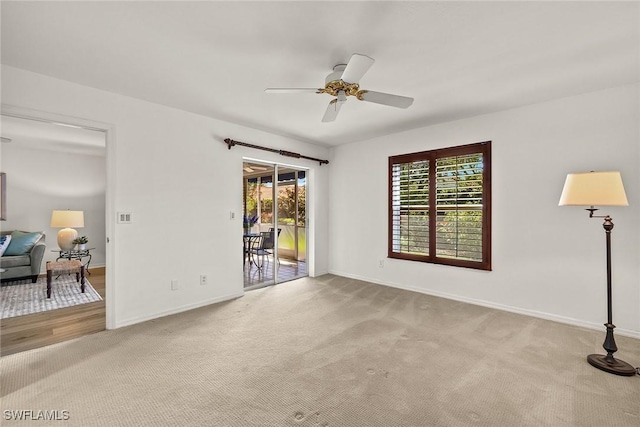 carpeted spare room with baseboards and a ceiling fan