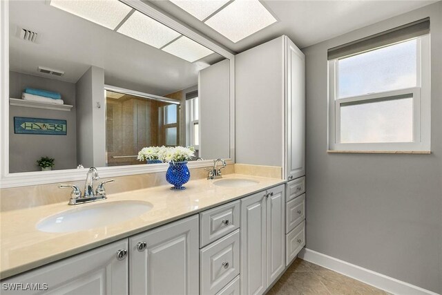 bathroom with a sink, visible vents, and a shower stall